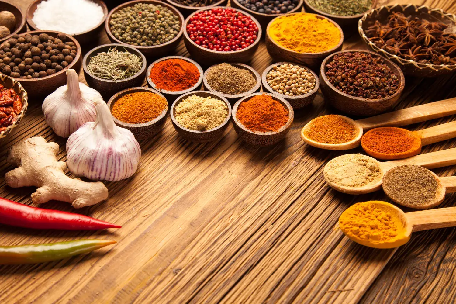 Spices, garlic and dried goods laid out across a wooden bench